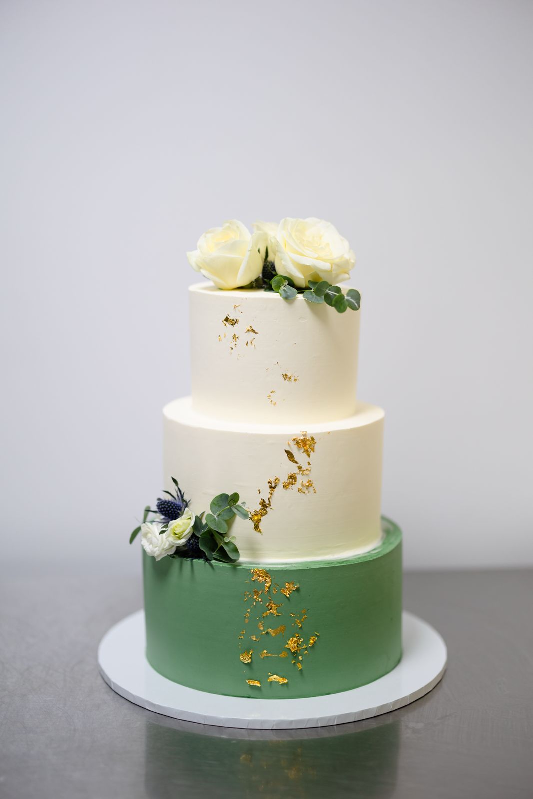 Elegant Three-Tier Cake with Gold Accents & Natural Flowers